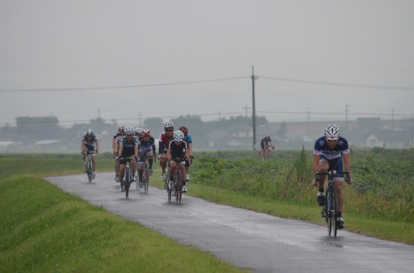 小雨の降り続く中を疾走する先頭集団